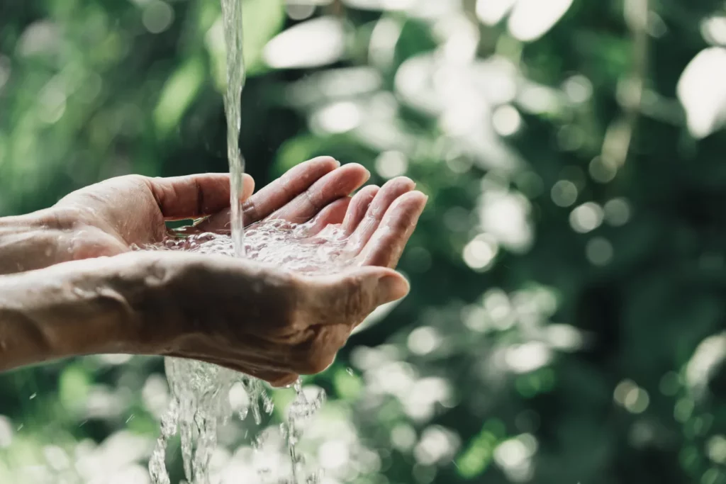 Main sous une source d'eau